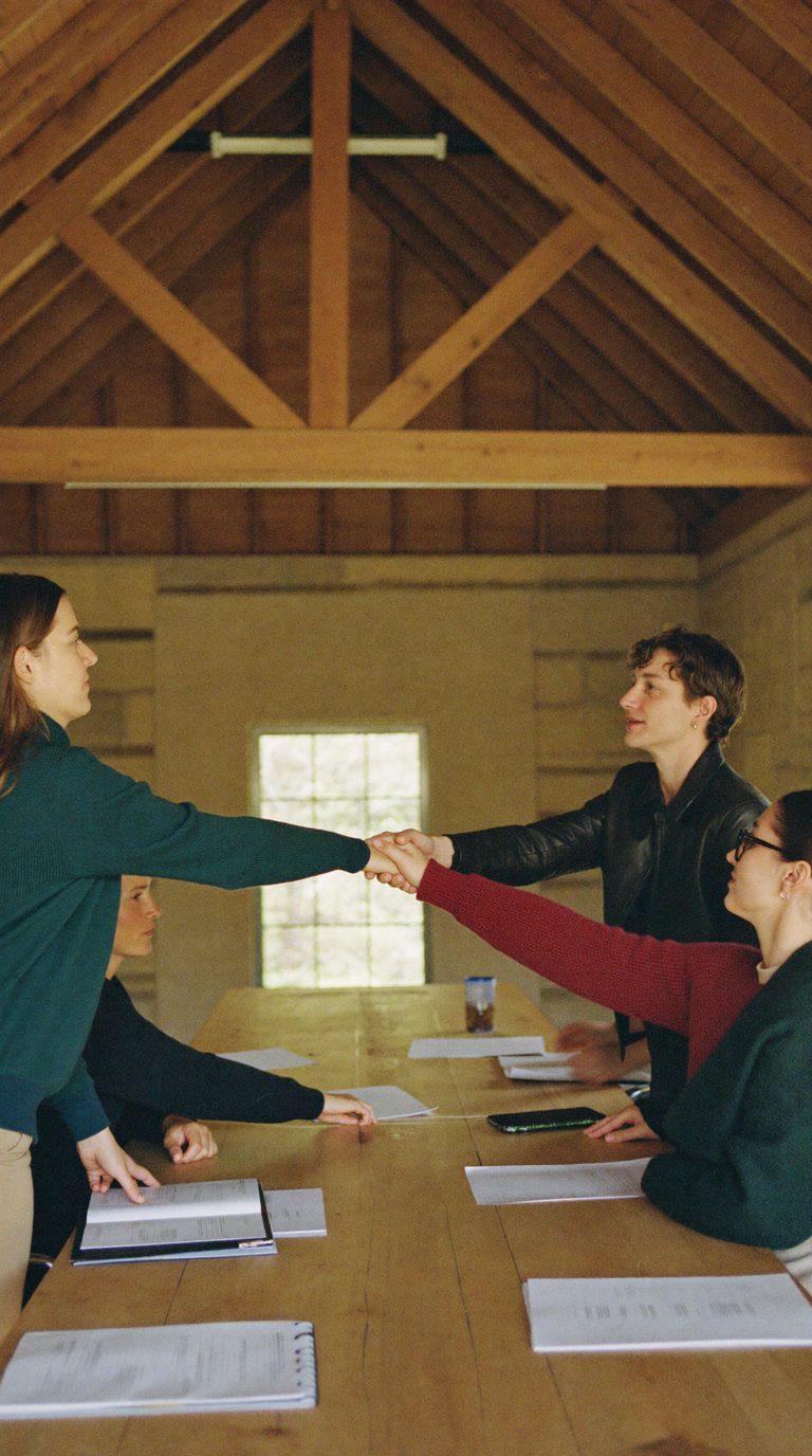 Profesionales de distintas áreas coordinándose alrededor de una mesa de trabajo